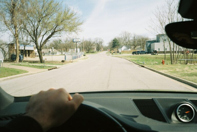 View from a car driving down a sunny suburban residential street