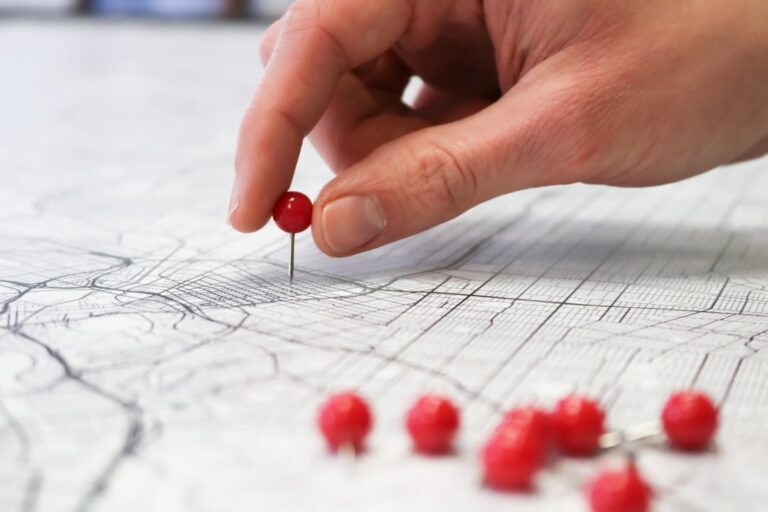 Red push pins on a city street map for choosing a wholesaling market