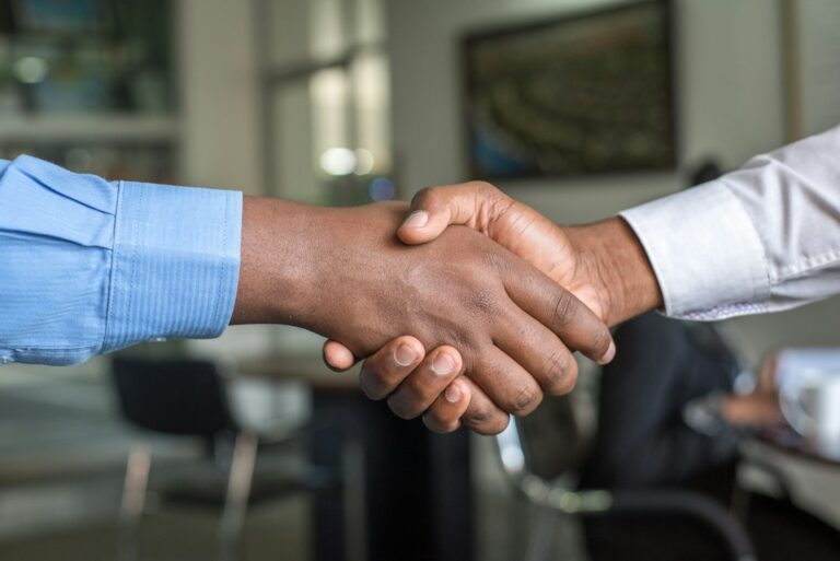 Two partners shaking hands, representing a joint venture wholesaling agreement