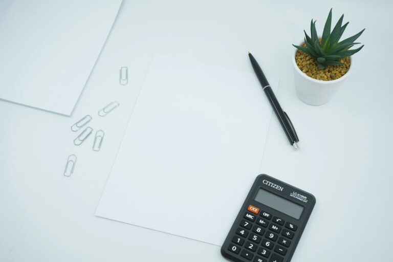 Blank paper, pen, and calculator on a desk for setting up an LLC for a wholesaling business