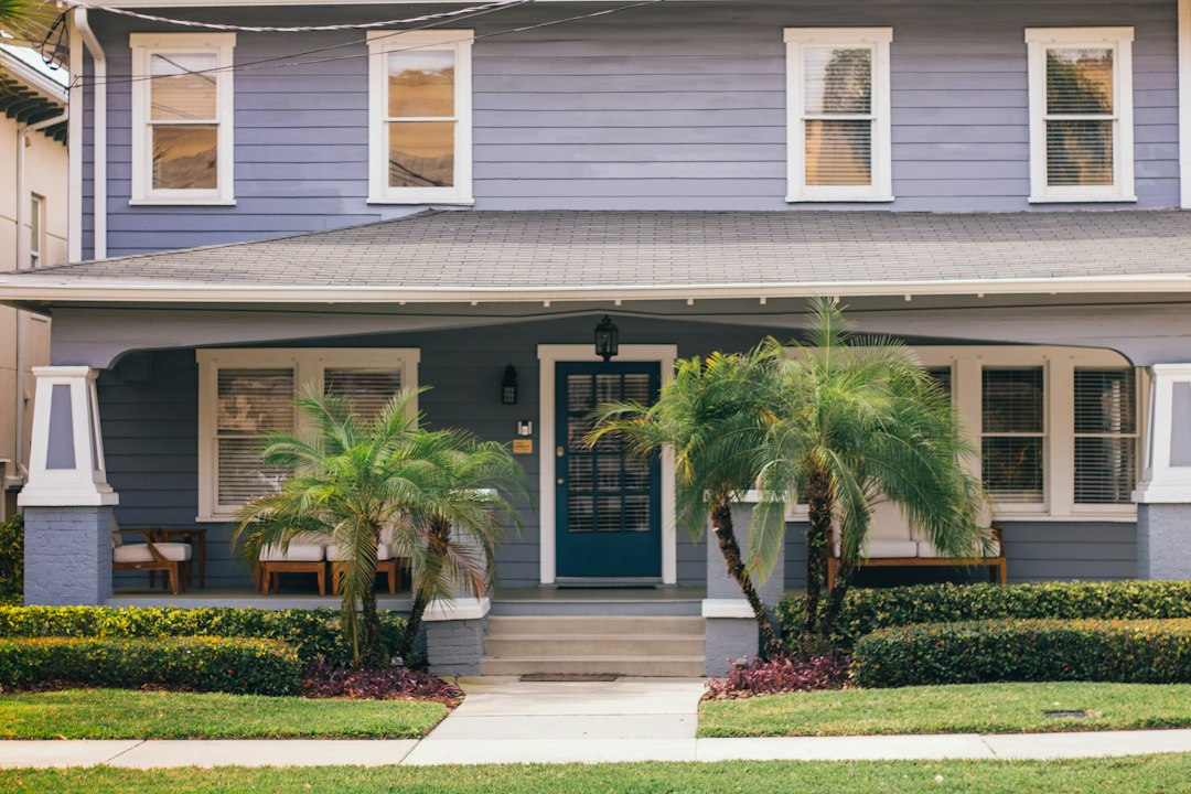 Blue single-family house with palm trees, the kind of Florida home that moves through the Florida foreclosure timeline