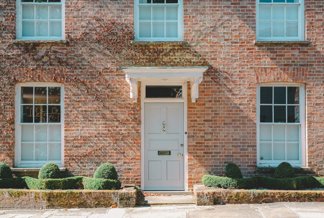 White front door on a brick house, the kind of doorstep a wholesaler visits when door knocking in real estate
