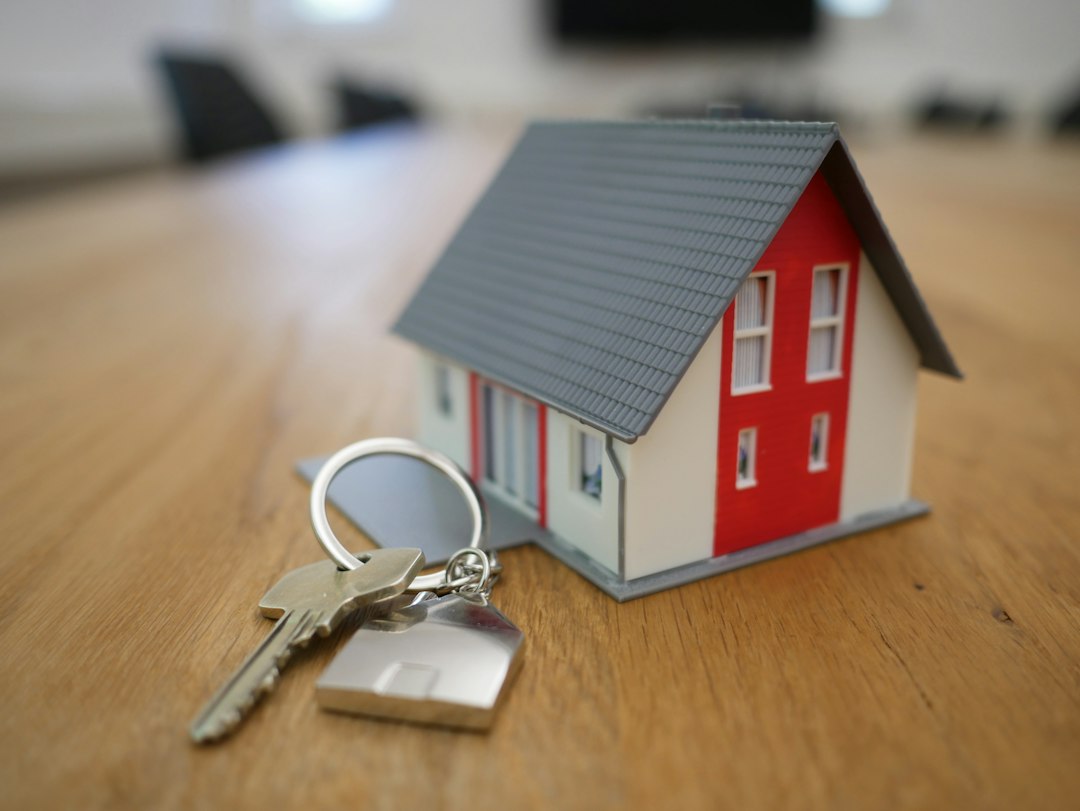 House keys and a small model home on a desk, illustrating the warranty deed vs quitclaim deed choice
