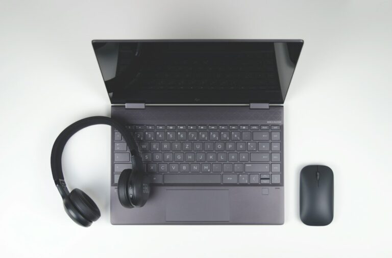 Laptop, headphones and mouse on a desk, the basic setup for a real estate virtual assistant making seller calls