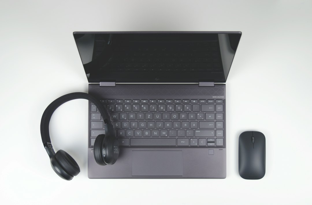 Laptop, headphones and mouse on a desk, the basic setup for a real estate virtual assistant making seller calls