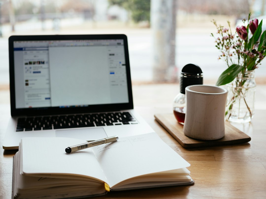 Laptop and notepad on a desk while setting up a CRM for real estate investors
