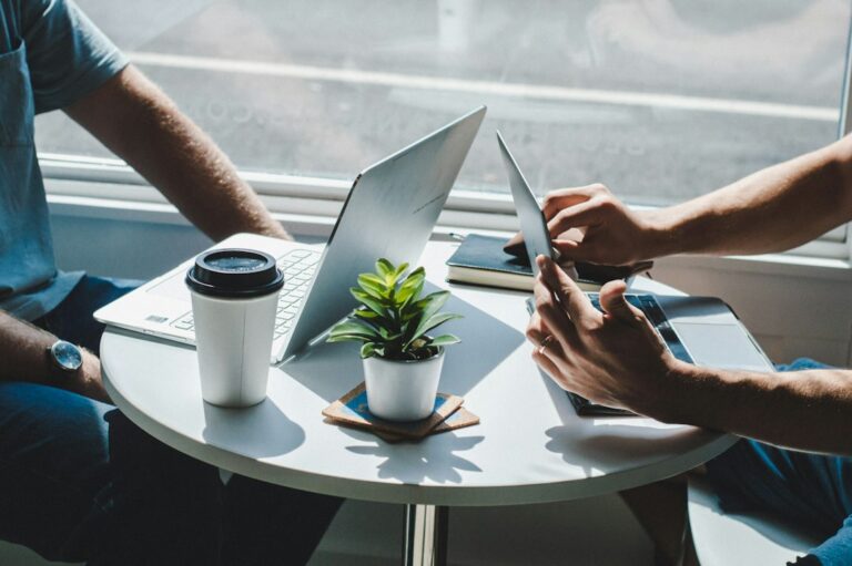 Investors meeting with laptops at a coffee shop to talk with private money lenders about a deal