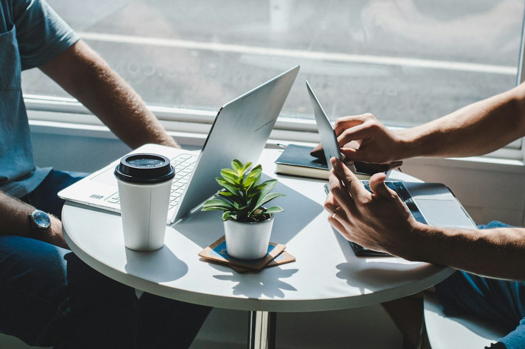 Investors meeting with laptops at a coffee shop to talk with private money lenders about a deal