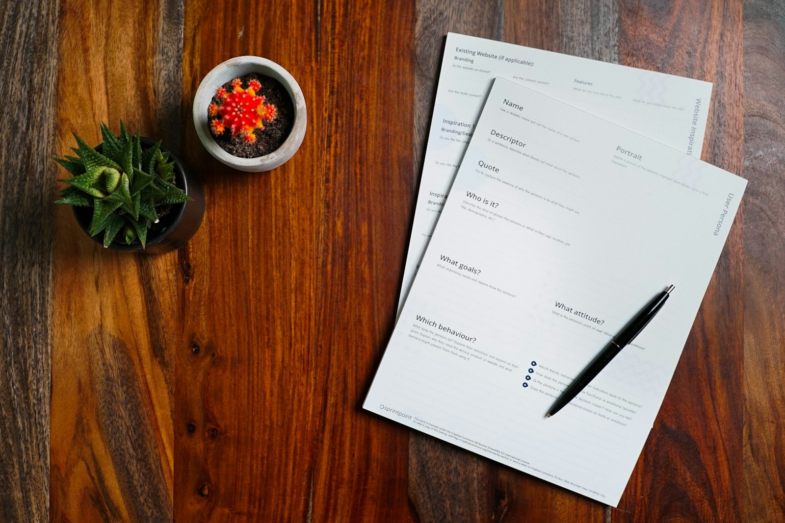 Loan papers and a pen on a wooden table, comparing deed of trust vs mortgage documents