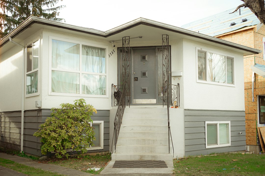 Renovated white house with a gray front door ready to sell as a turnkey rental property