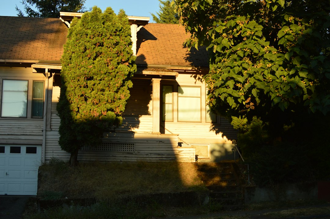Rental house with light siding and a garage at golden hour, the kind of property landlords price using cap rate in real estate