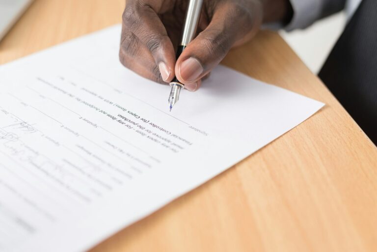Person signing closing documents, where title insurance for investors is bought at the closing table