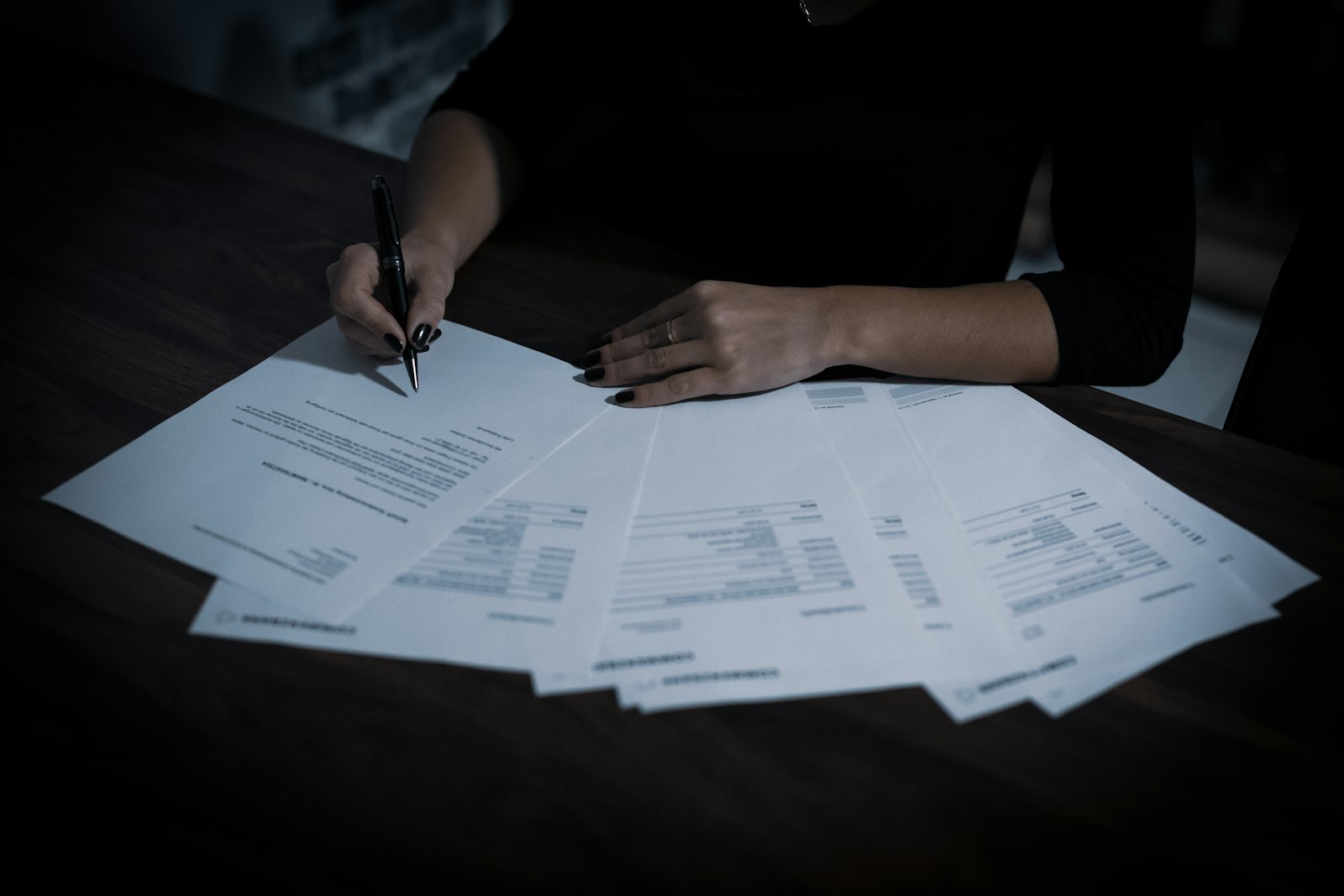 Person signing property title documents with a ballpoint pen during a quiet title action