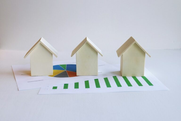 Three small model houses on a sheet of paper, illustrating equitable interest in real estate under a purchase contract