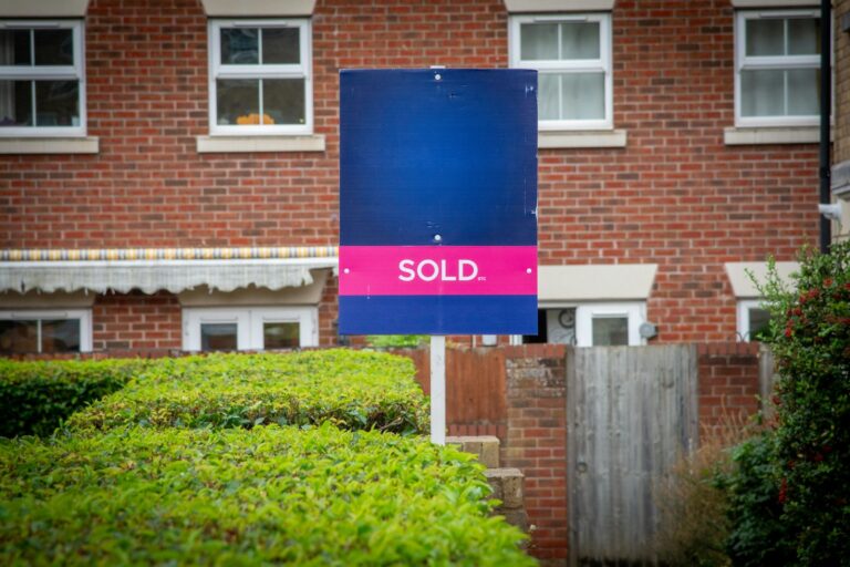 Sold sign in front of a brick house, the retail resale step in wholetailing real estate
