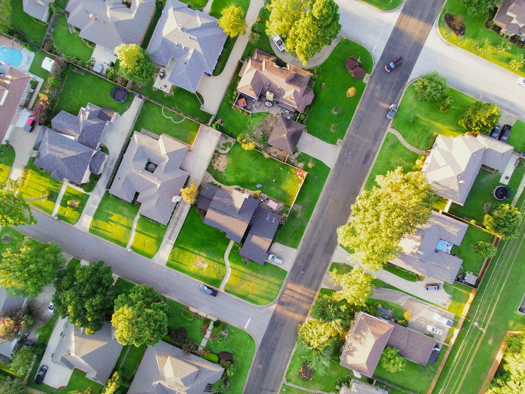 Vacant residential lot between suburban homes, illustrating highest and best use analysis for an investment property