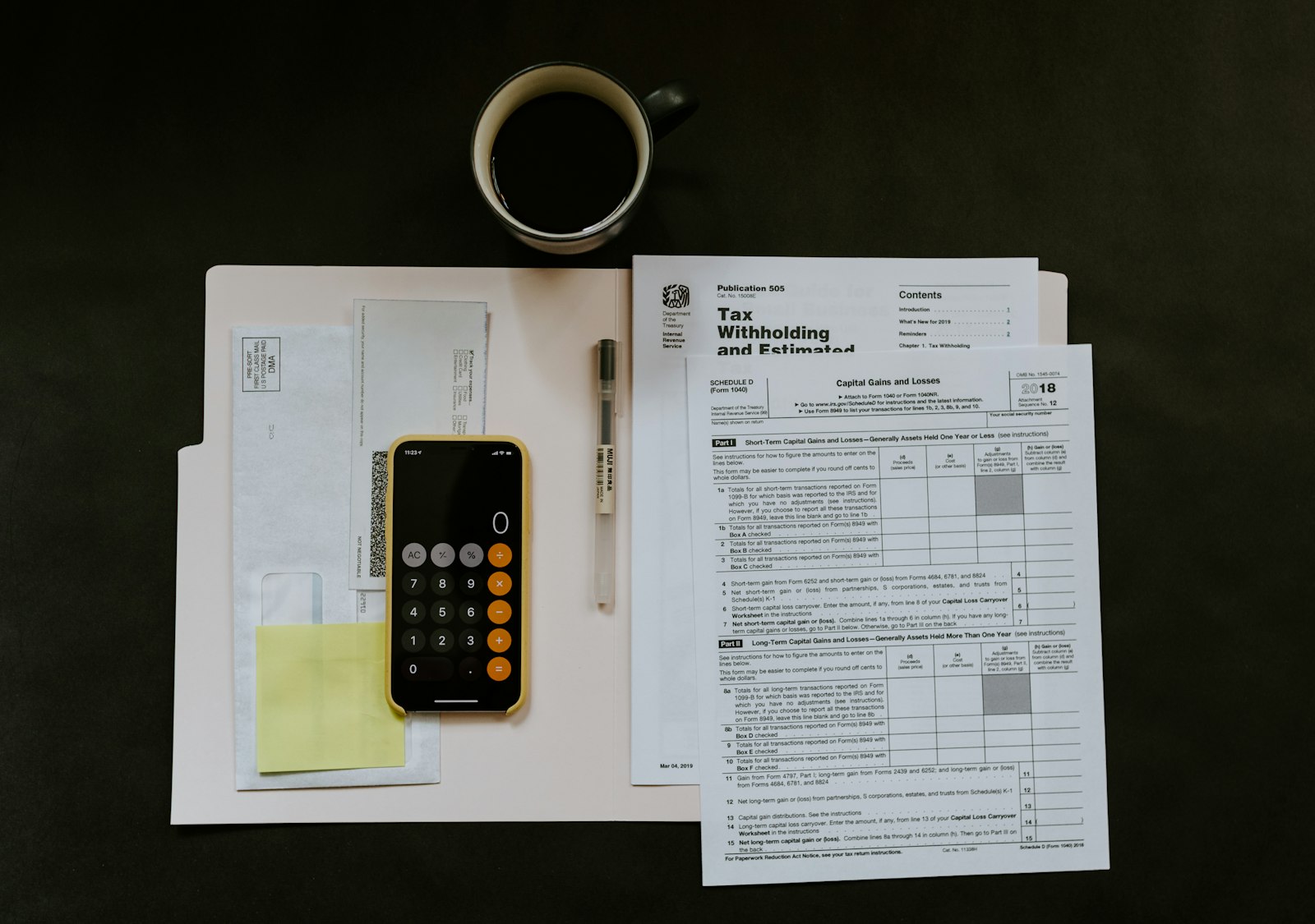 Tax form, pen and phone on a folder, the paperwork used to work out real estate transfer tax at closing