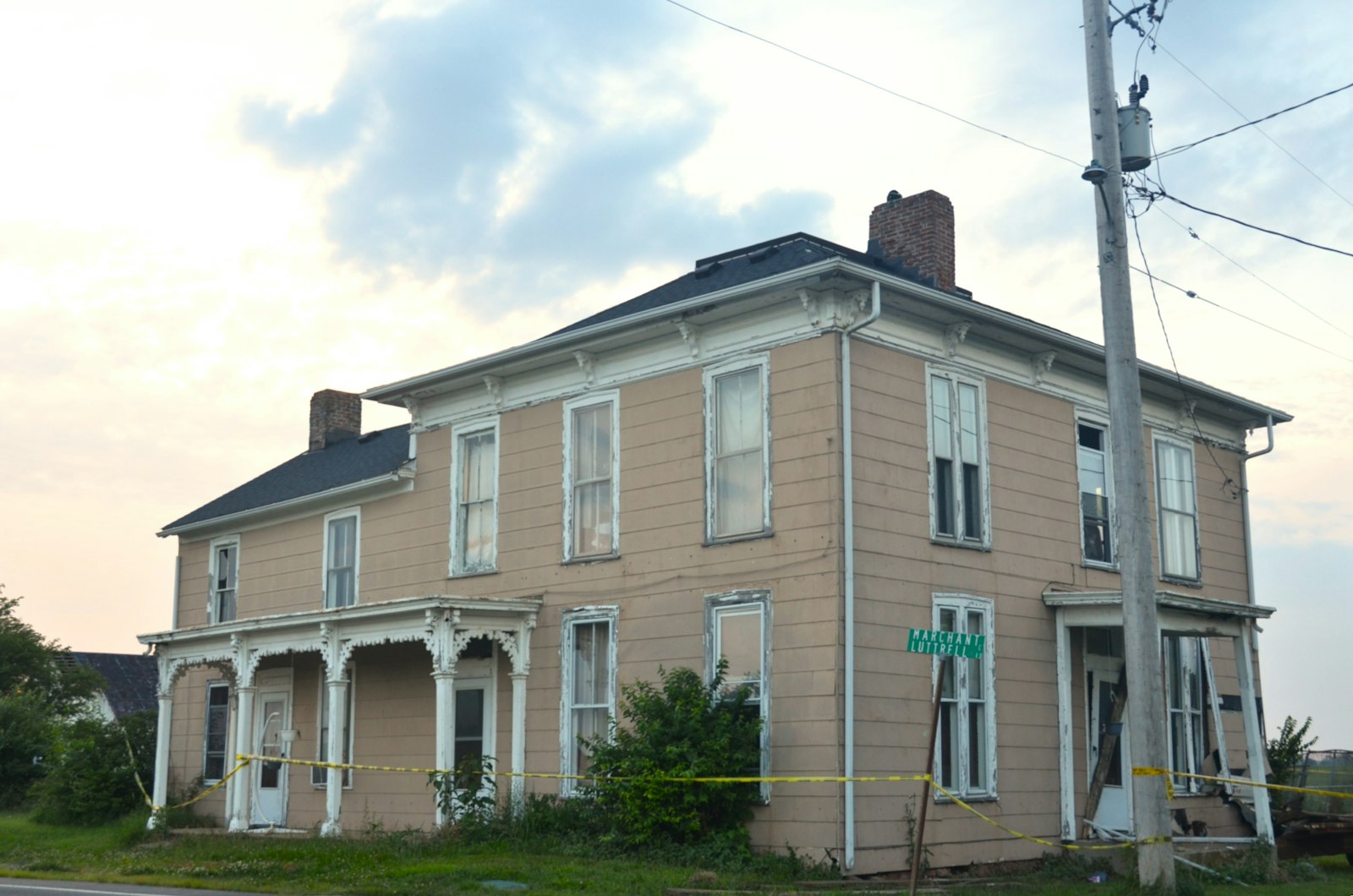 Older two-story frame house with worn porches, the kind of property that shows up in code violation leads